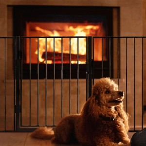Schwarzes Juskys Kamin Ofenschutzgitter 300 cm mit Hund vor brennendem Kamin.