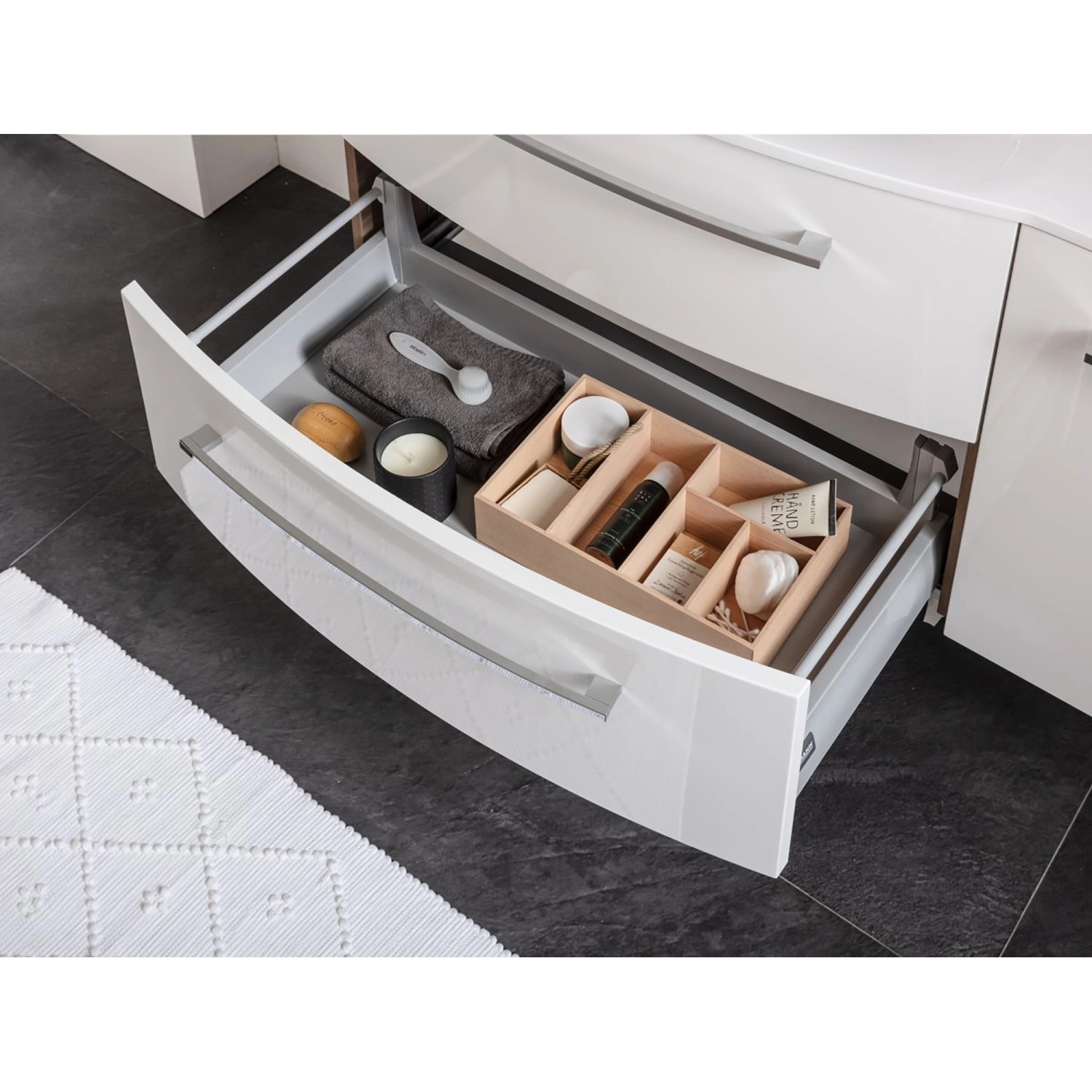 Offene Schublade eines Fackelmann Spiegelschranks Verona (110cm) in Weiß Glanz mit Badutensilien.