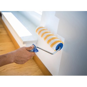 Hand streicht Wand mit LUX Farbroller Glatt 26,5 cm. Farbwalze mit gelben Streifen.