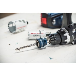 Bosch Power Change Plus System 8,7 mm im Bohrfutter einer Bohrmaschine, Lochsägen im Hintergrund.
