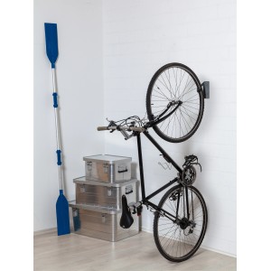 Fahrrad hängt an LUX Fahrradhaken (13,5 kg) an weißer Wand. Ruder und Aluboxen im Hintergrund.