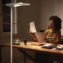 Weiße Ledvance Sun@Home Smart+ Stehlampe, 180 cm, im Homeoffice mit Frau am Schreibtisch.