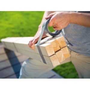 Hände bündeln Holz mit silbernem LUX-TOOLS Gewebeband. Robustes Panzerband für Reparaturen im Garten oder Haushalt.