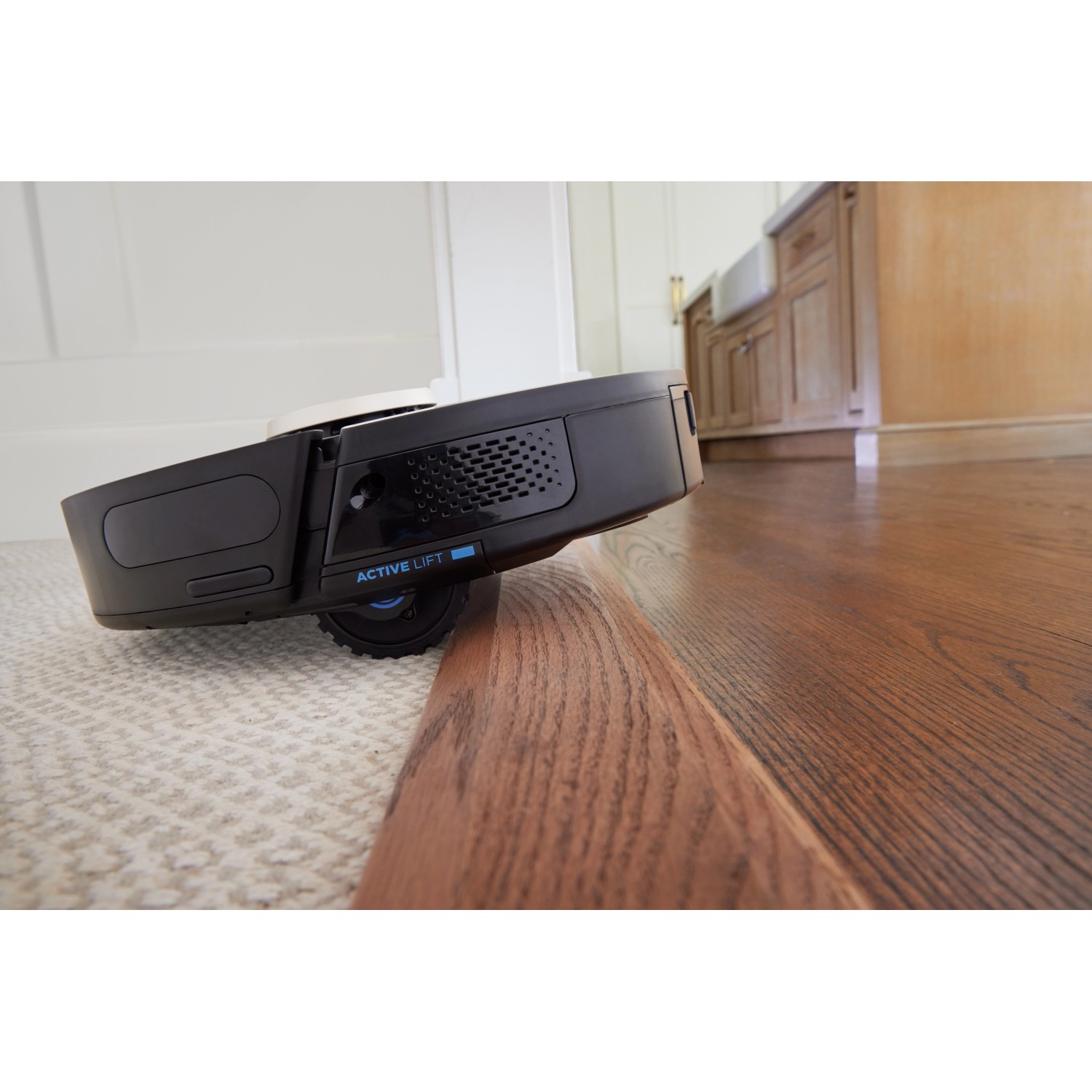 Shark Saugroboter Power Detect RV2820VEEU beim Übergang von Teppich zu Holzboden.