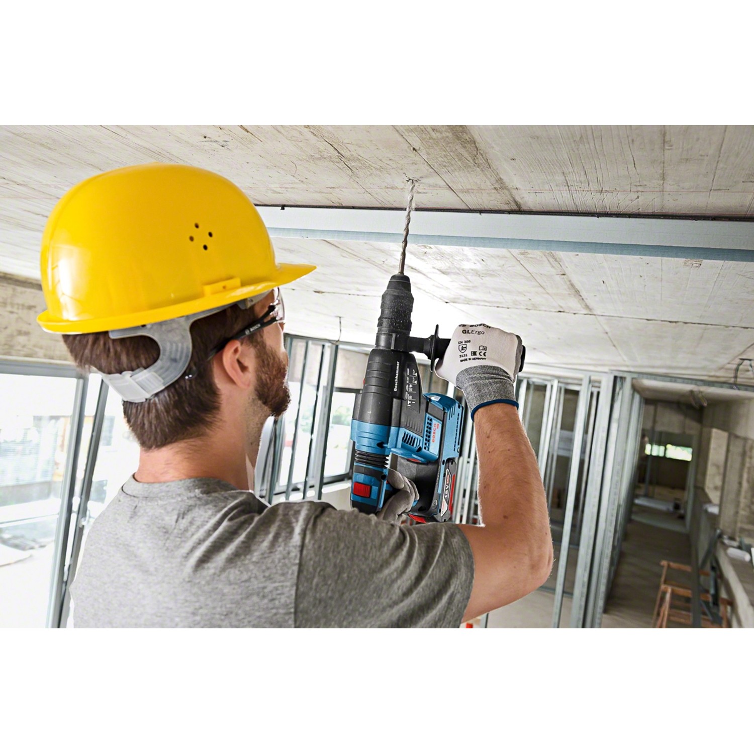 Handwerker bohrt mit Bosch Akku-Bohrhammer GBH 18V-26 ein Loch in die Decke.