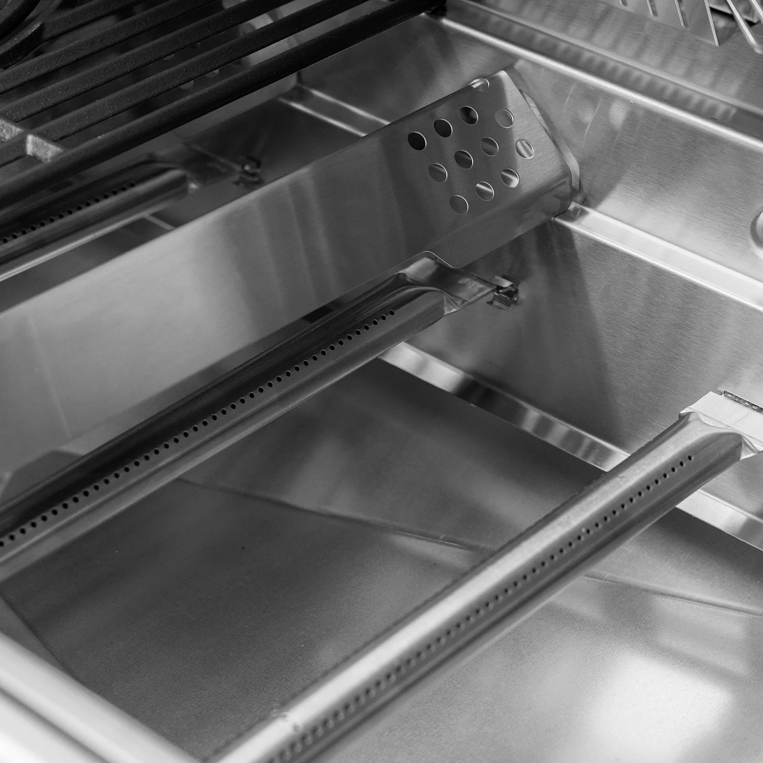 Detailaufnahme: Edelstahl-Brenner und Grillrost des Taino Platinum Yamara Gasgrills.