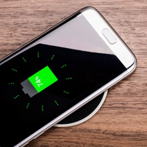 Smartphone lädt kabellos auf schwarzem SOTECH JUNKER Einbau Wireless Charger, in Holztisch integriert, 74% Akku.