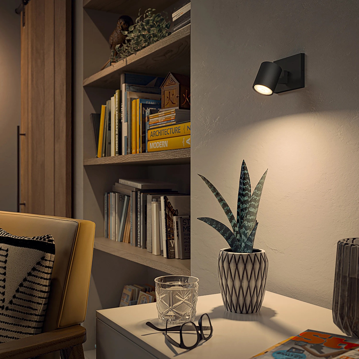 Schwarzer Philips Hue LED-Spot Runner an Wand über Tisch mit Deko-Elementen.