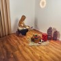 Frau baut künstlichen Weihnachtsbaum Nagano (150cm) auf. Deko-Elemente im Raum.
