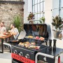 Char-Broil Gas2Coal 330 Kombigrill mit 3 Brennern und offener Grillfläche mit Grillgut.