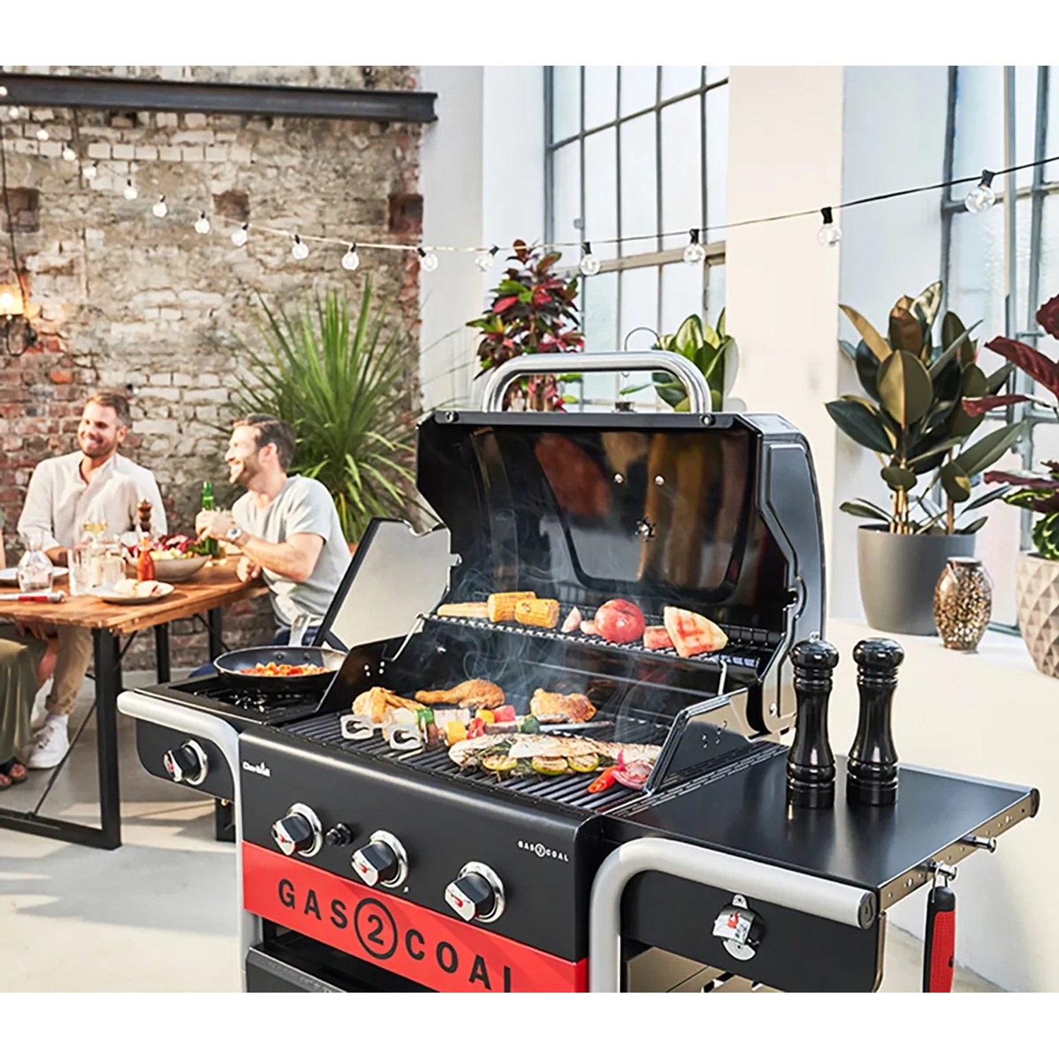 Char-Broil Gas2Coal 330 Kombigrill mit 3 Brennern und offener Grillfläche mit Grillgut.