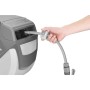 Hand zieht grauen FUXTEC Gartenschlauch aus automatischem 20m Wasserschlauchaufroller. Schlauch mit Anschluss.
