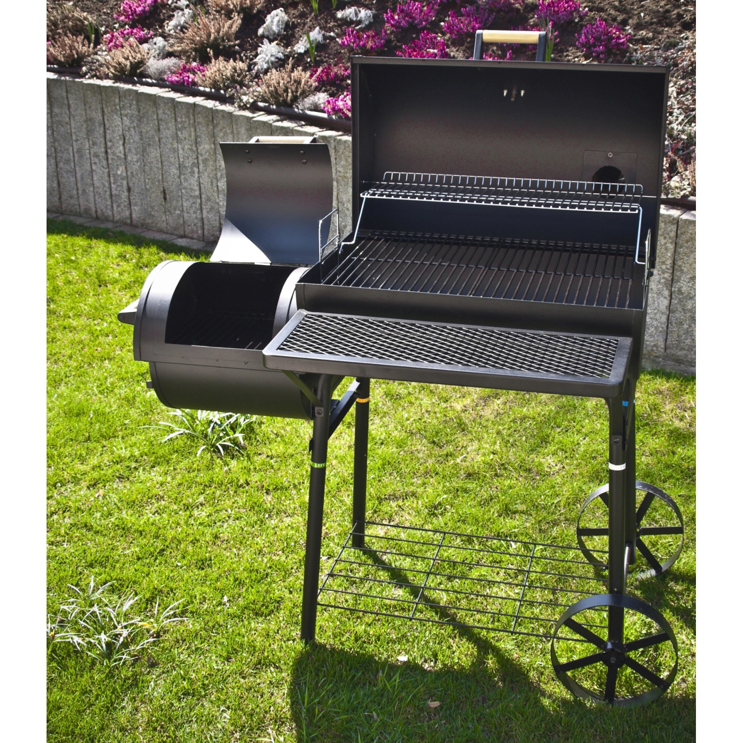 El Fuego Dakota Holzkohlegrill Smoker mit zwei Grillflächen und Ablagen auf Rasen.