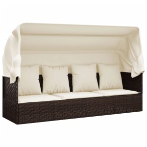 Braunes Outdoor-Loungebett mit Dach und cremeweißen Kissen aus Polyrattan.