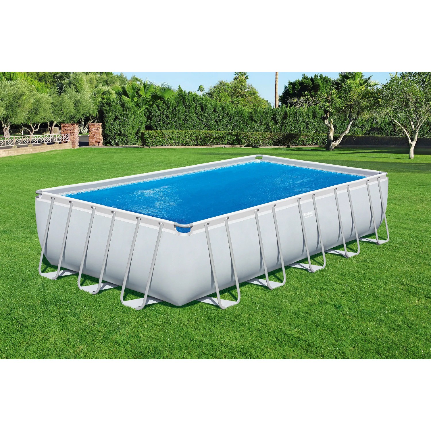 Rechteckiger Pool mit blauer Bestway Solar Abdeckung 703x336 cm auf Rasen.