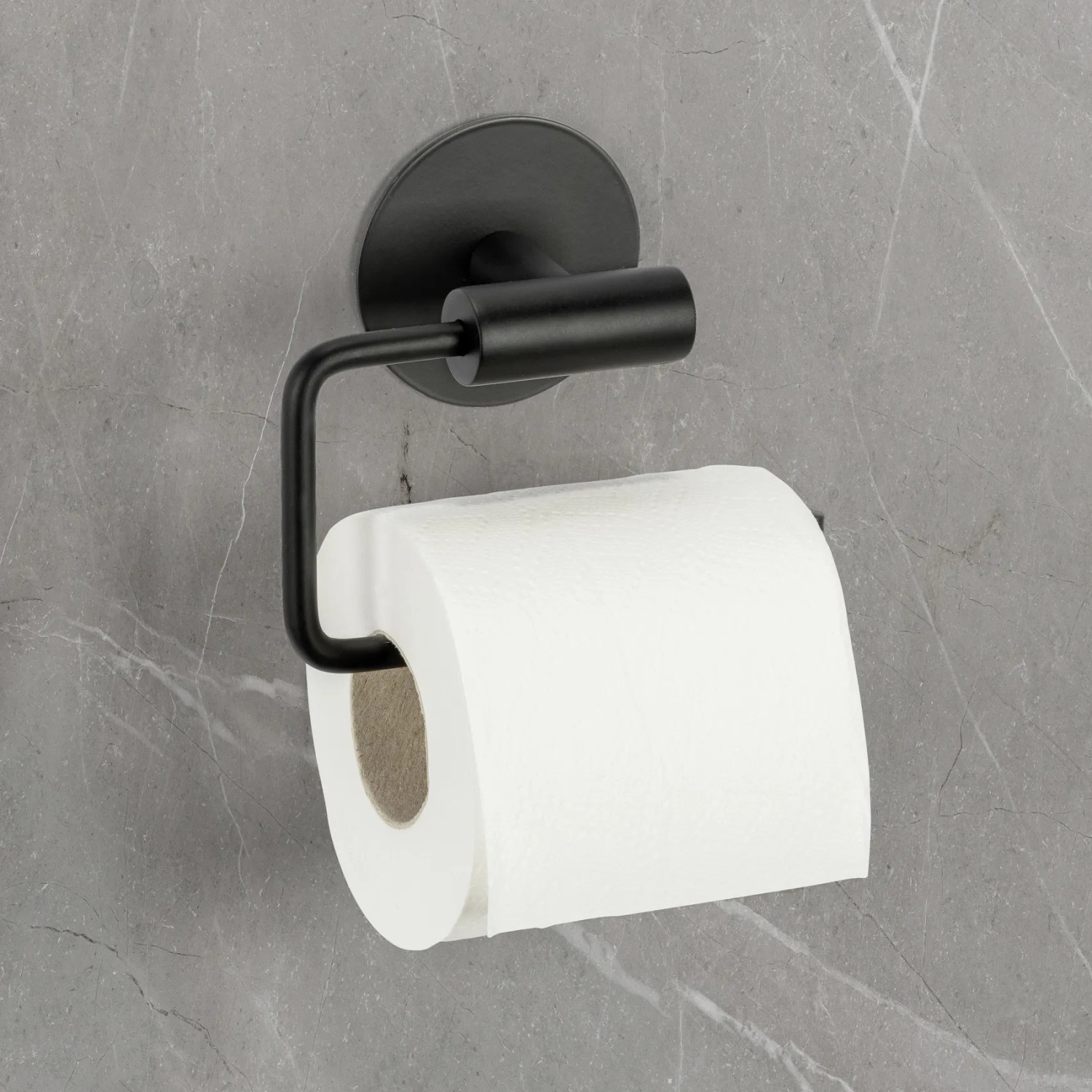 Schöner Wohnen Toilettenpapierhalter Meleto, schwarz, mit Papierrolle an grauer Wand.
