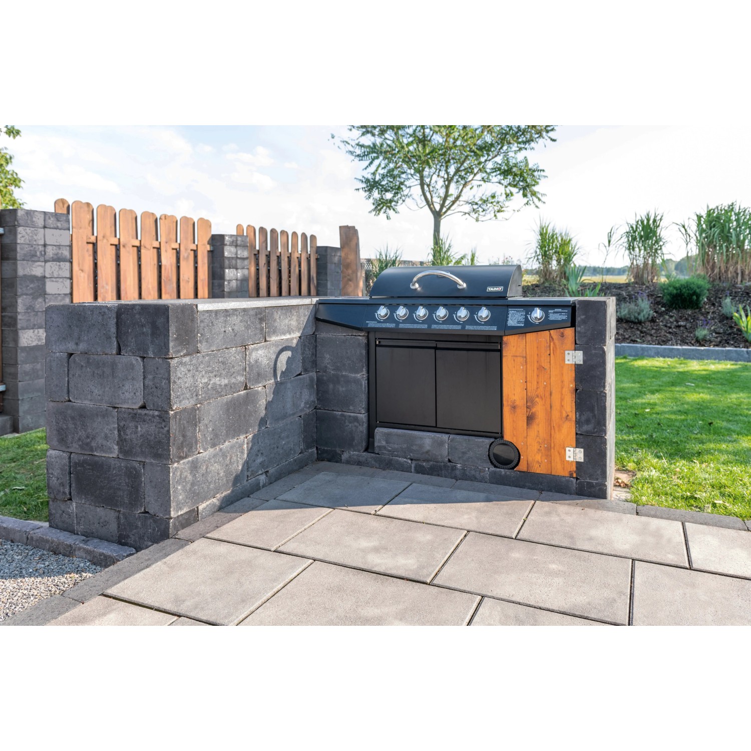 Diephaus Collo Mauerstein Basalt: Graue Mauersteine umrahmen einen Grillplatz im Garten.