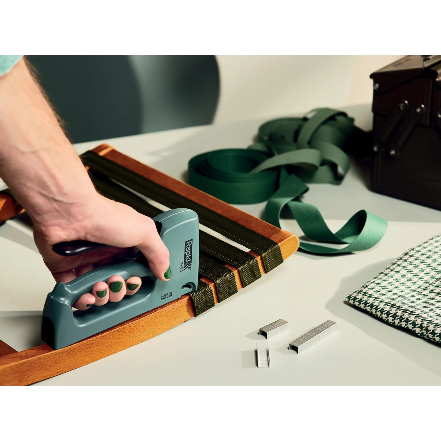 Hand tackert Textil mit Rapid Tacker. Klammern Typ 53/8 mm sichtbar.