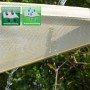 Detailaufnahme: Beiges, wasserdurchlässiges AMANKA Sonnensegel aus HDPE im Einsatz.