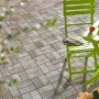 Verlegte Rechteck-Pflastersteine Jura-Nuanciert (20x10x6 cm) auf Terrasse mit Gartenmöbeln.