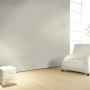 Glööckler Vliestapete Imperial Miniaturfedern Uni Beige im Raum mit Sessel und Lampe.
