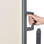 Detailaufnahme: Beige Juskys Seitenmarkise Dubai, Hand am Griff zum Ausziehen.