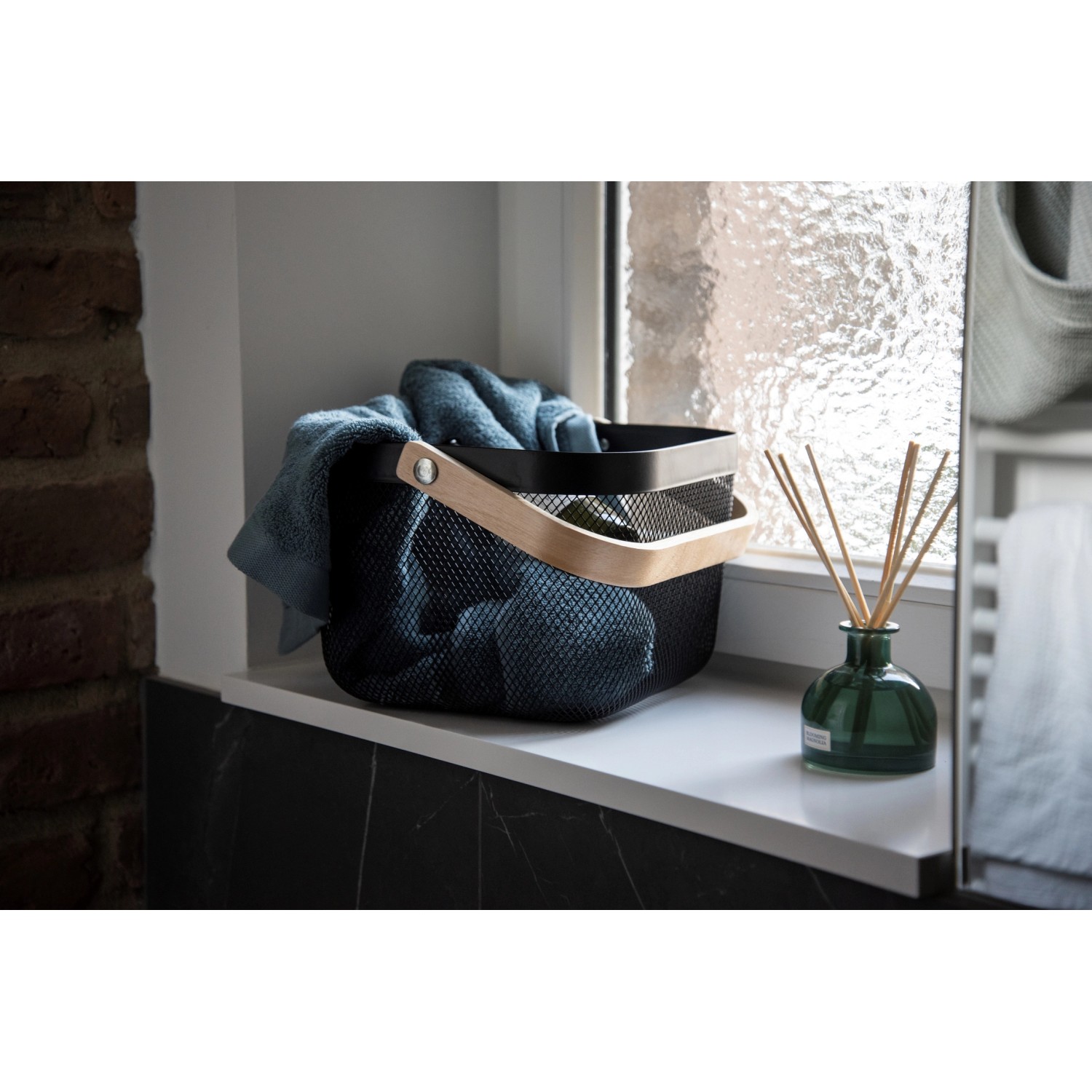 WENKO Badaufbewahrung Bambusa: Schwarzer Metallkorb mit Bambusgriff, gefüllt mit Handtüchern.