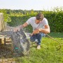 Mann reinigt Gardena Mähroboter smart Sileno life 750 mit Wasserschlauch auf Rasen.