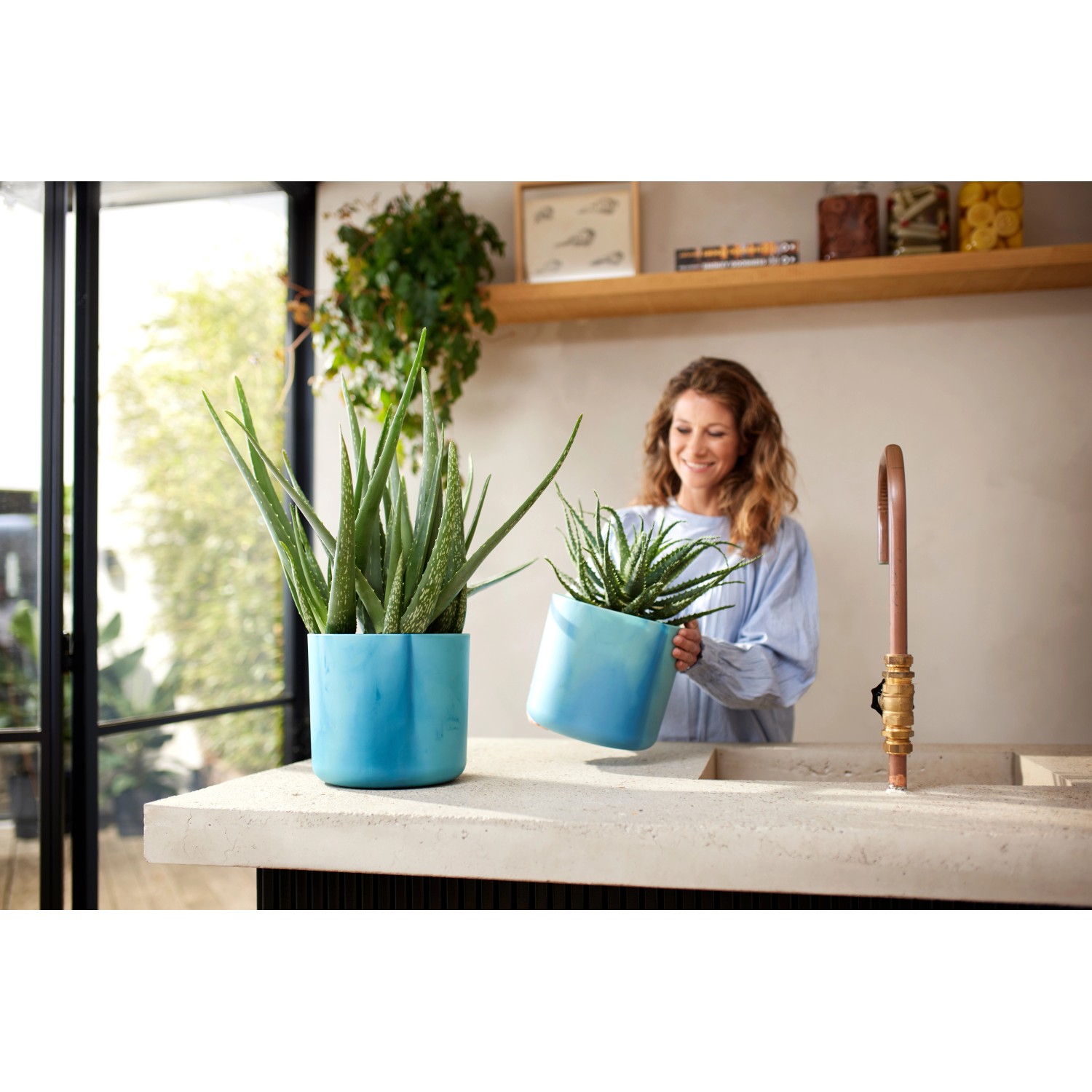 Elho Blumentöpfe Ocean Collection, Ø 16 cm, atlantikblau, mit Pflanzen auf einer Küchentheke.