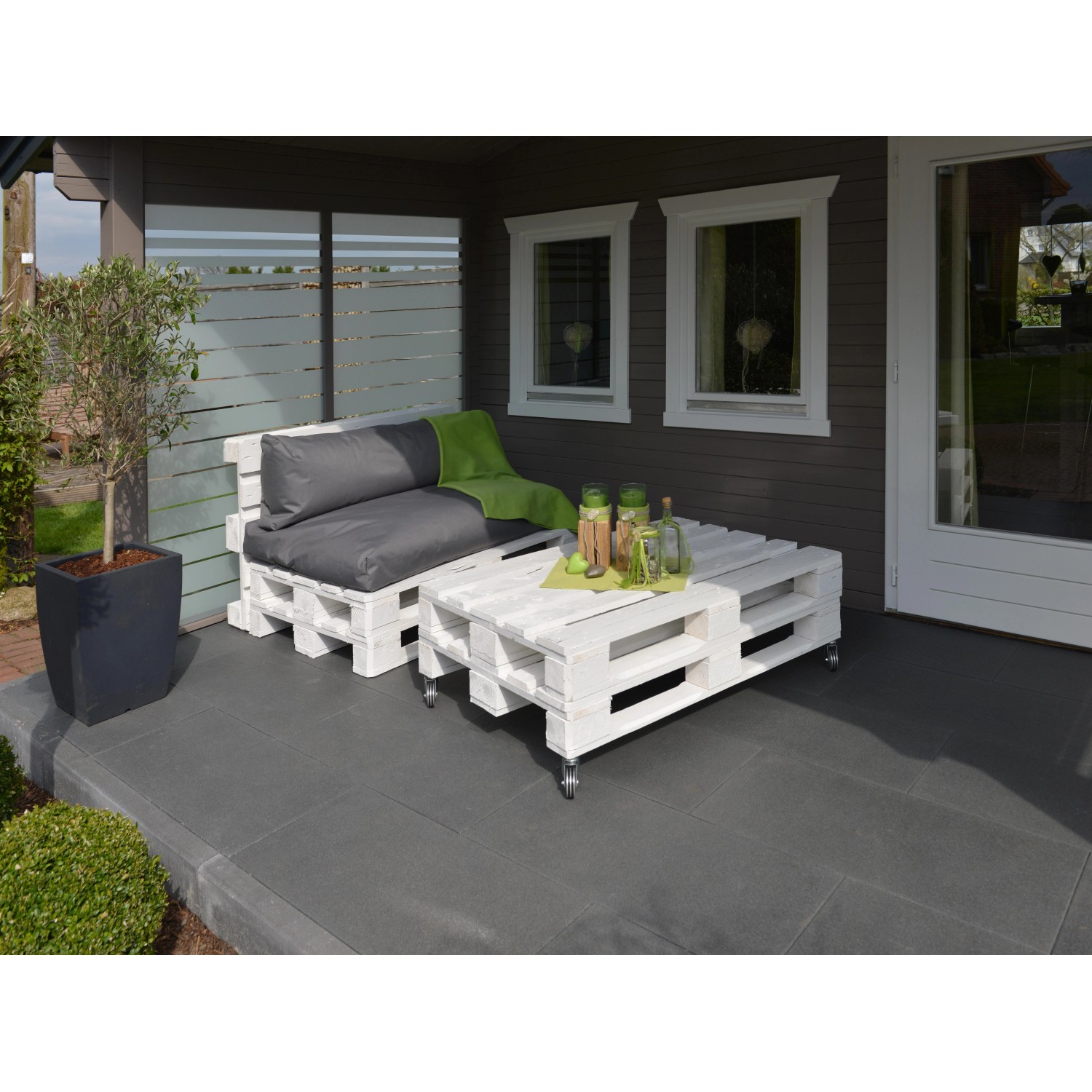 Weiße Möbelpaletten für den Außenbereich als Lounge-Set mit Tisch und Sitzkissen.