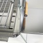 Detailaufnahme: Grillpeter Mangal Astana Edelstahl Grill mit Rost und Holzgriff.
