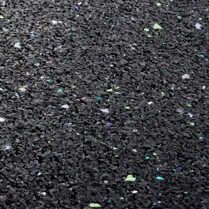 Nahaufnahme der schwarzen KARAT Antivibrationsmatte / Schallschutzmatte mit farbigen Sprenkeln.