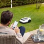 Mann steuert ECOVACS Mähroboter GOAT G1 per App im Garten.