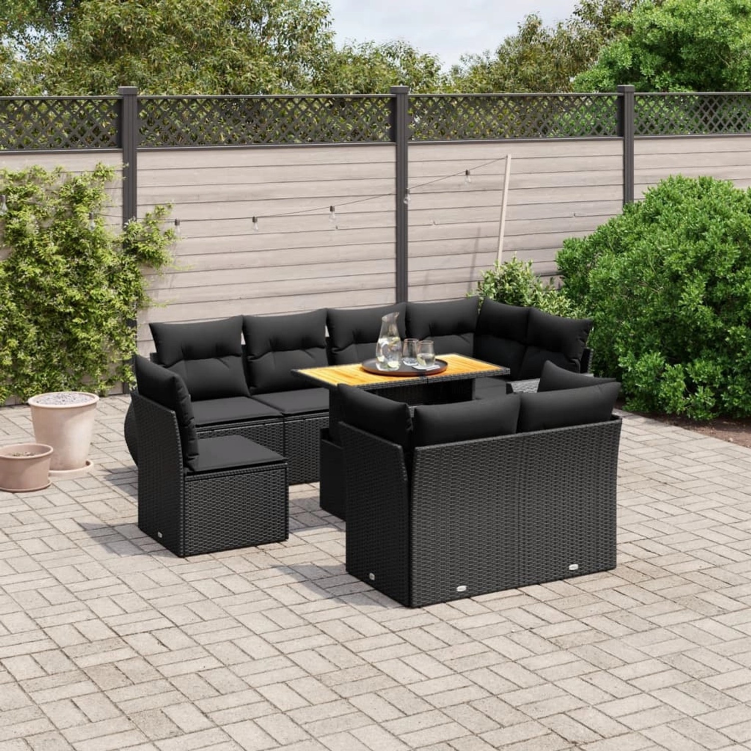 Schwarze 9-teilige Garten-Sofagarnitur aus Poly Rattan mit Tisch und Kissen.