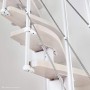 Detailansicht der Intercon Raumspartreppe Alpha: helle Buchenholzstufen, weißes Metallgestell, filigranes Geländer.