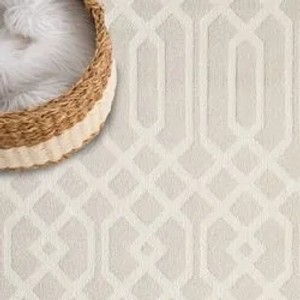 Beiger, runder Hochflor Teppich Esso 200x200 cm mit geometrischem Muster und Korb.