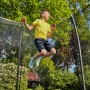 Junge springt auf grünem Salta Gartentrampolin Comfort Edition mit Sicherheitsnetz.
