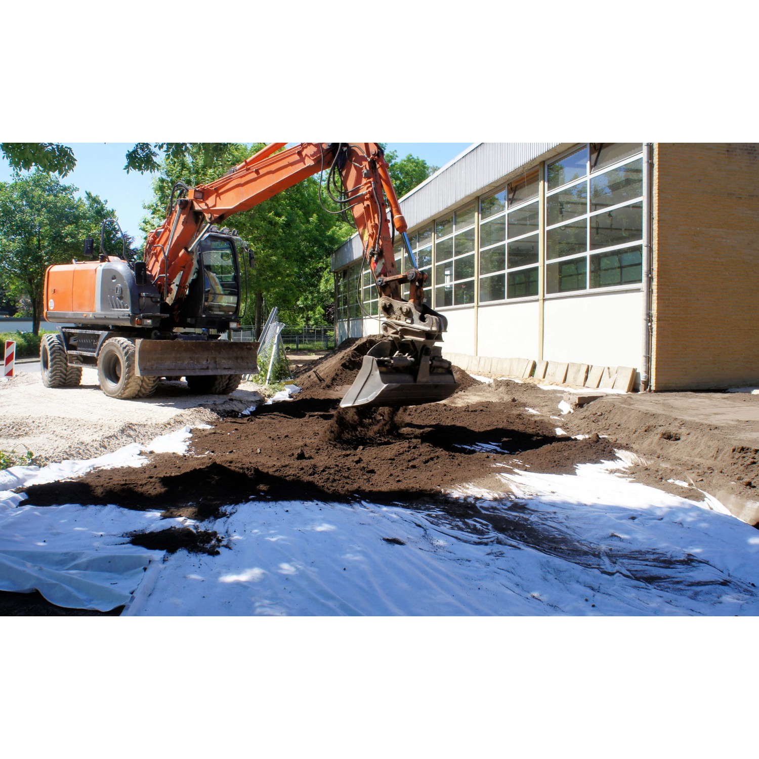 Verlegung von Aquagart Gartenvlies 150g unter Erde mit Bagger im Gartenbau.