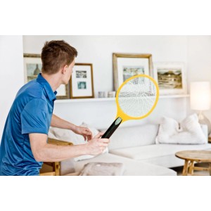 Mann benutzt gelbe Windhager elektrische Fliegenklatsche im Wohnzimmer zur Insektenabwehr.