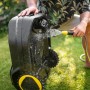 Kärcher RCX 4 Mähroboter wird mit Wasserschlauch gereinigt. Kabelloser Rasenmäher mit Igelerkennung.