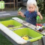 EXIT Aksent Sand-, Wasser- und Picknicktisch mit Kind beim Spielen im Garten.