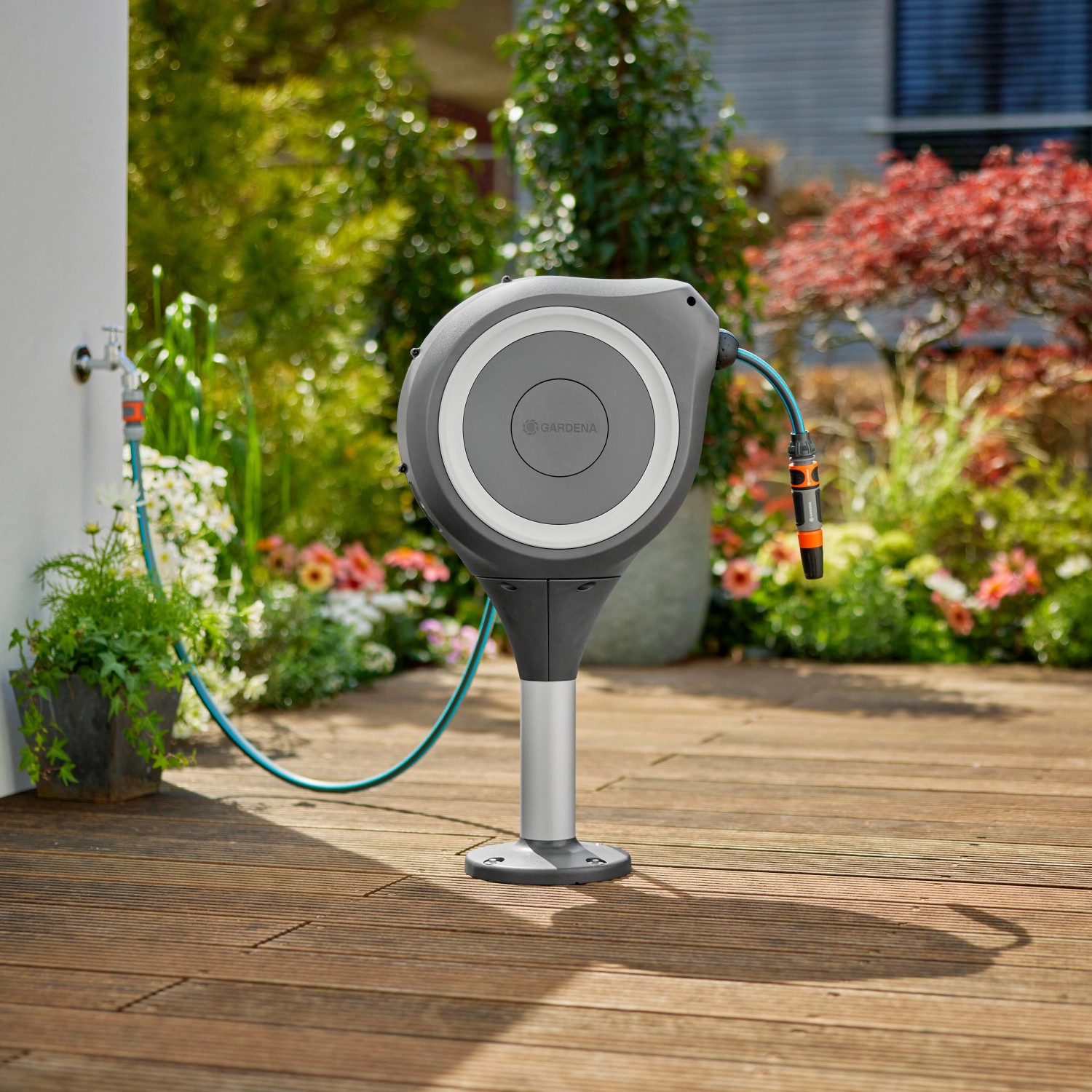 Gardena Terrassen-Schlauchbox RollUp S mit 15m Gartenschlauch auf Holzterrasse.