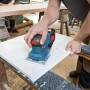 Bosch Professional GSS 18V-10 Akku-Schwingschleifer im Einsatz beim Schleifen einer weißen Oberfläche.