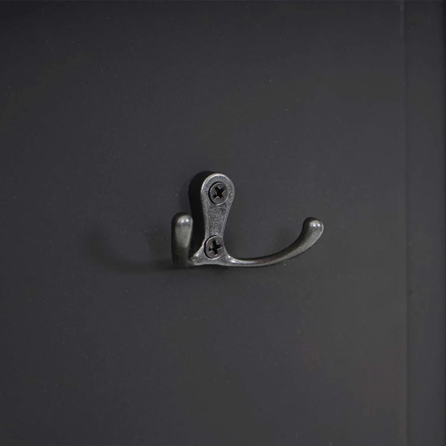 Detailaufnahme: Dunkelgraue MCW Wandgarderobe mit Metallhaken.