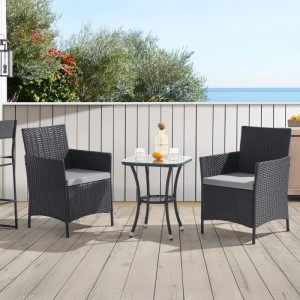 Schwarzes 3-tlg. Rattan Gartenmöbelset mit 2 Sesseln, grauen Kissen und Glastisch auf Balkon. Outdoor Lounge.