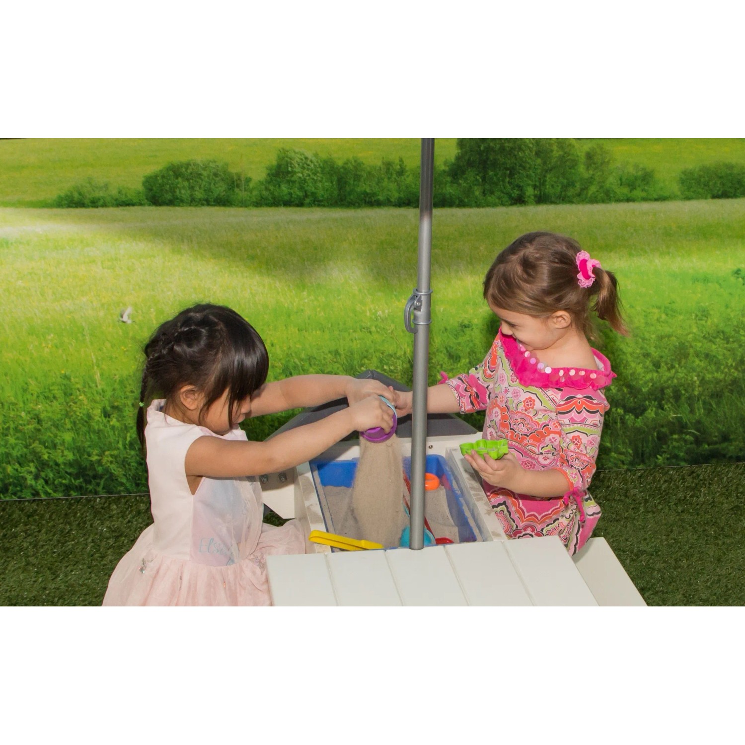 Sand- und Wassertisch Delta mit Sonnenschirm: Kinder spielen mit Sand und Förmchen im Garten.