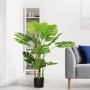 HOMCOM Künstliche Pflanze 120 cm mit großen grünen Blättern im schwarzen Übertopf, im Wohnzimmer neben Sofa.