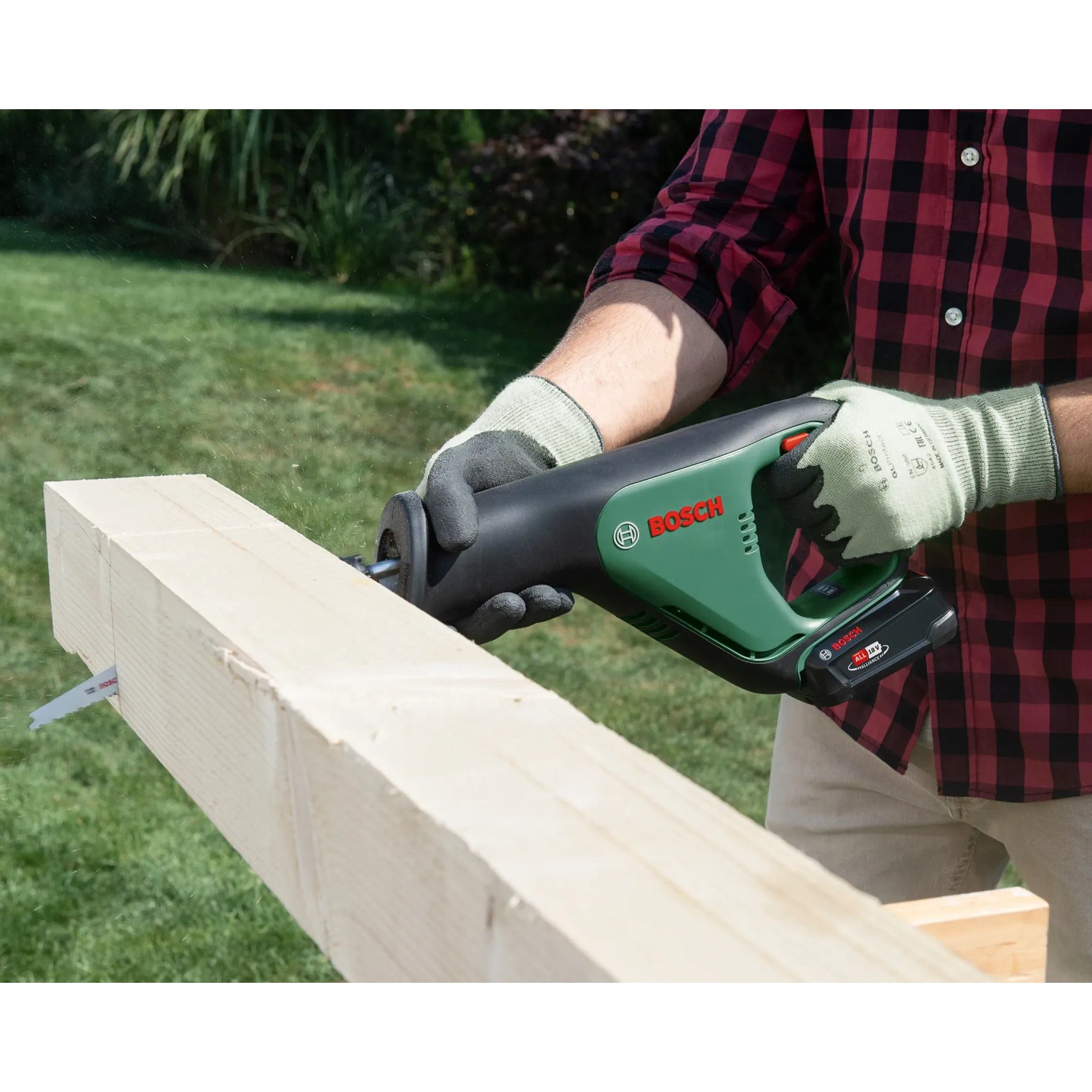 Bosch AdvancedRecip 18 Akku-Säbelsäge beim Sägen eines Holzbalkens im Garten.