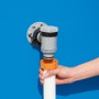 Detailaufnahme: Montage der Bestway Flowclear Sandfilteranlage am Pool. Schlauch wird angeschlossen.