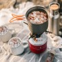 Evocamp Gaskartusche beim Camping: Topf mit Marshmallows auf Gaskocher, Tassen und Wasserflasche im Hintergrund.